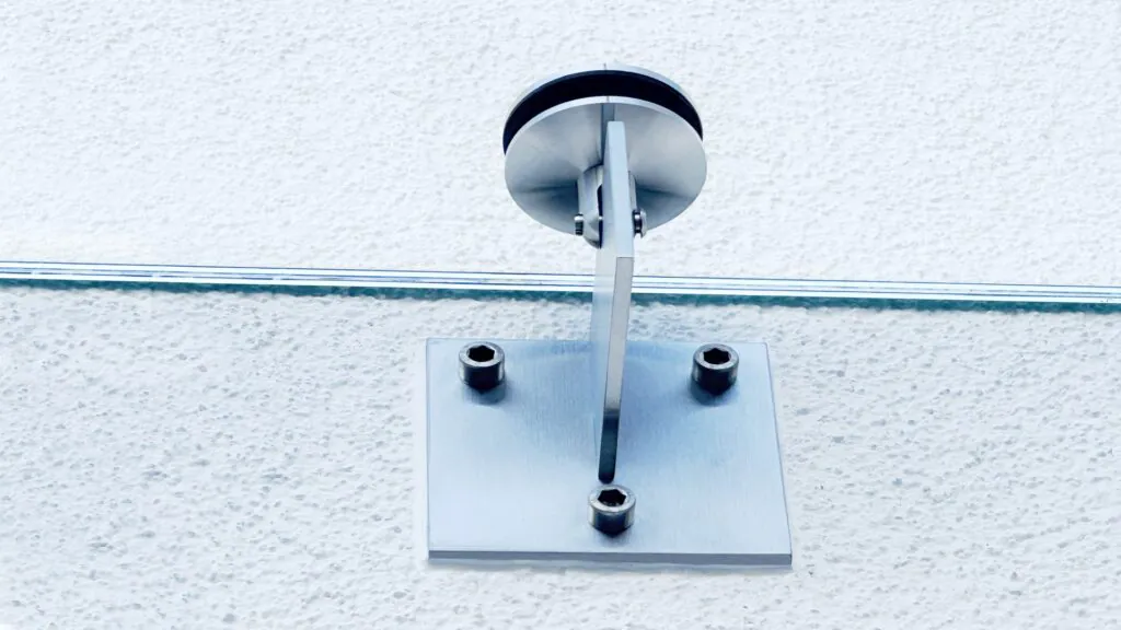 Detailaufnahme eines Punkthalters zur Befestigung eines Glasvordaches – robuste und stilvolle Konstruktion.