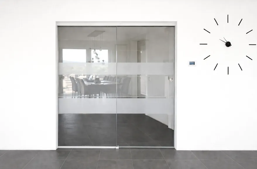 Ganzglasschiebetür mit Seitenteil, Deckenmontage und Sandstrahlstreifen – stilvolle Raumtrennung mit elegantem Design.
